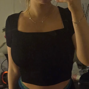 Svart topp med kvadratisk urringning - Halloj, säljer denna svarta toppen med en kvadratisk urringning. Säljs på grund av att jag köpte 2 och behöver enbart 1. Köpte den på New Yorker och den är i storlek S! Sitter väldigt bra och ger en fin urringning. 