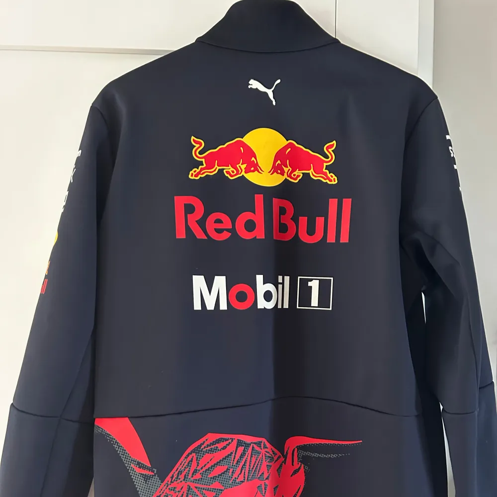 En svart jacka ifrån Red Bull Racing. nästintill aldrig använd, inga täcken på användning storlek M. Jackor.