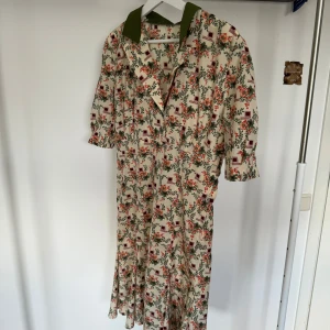 Vintage klänning 40-tal  - Säljer en vintage klänning från 40-talet! Otroligt vacker men en figursydd kjol och en volang längs nederhemmen!   Aldrig använd  Då klänningen är hemmasydd finns varken märke eller storlek, men klänningen passar storlek M!  (Köparen står för frakt)