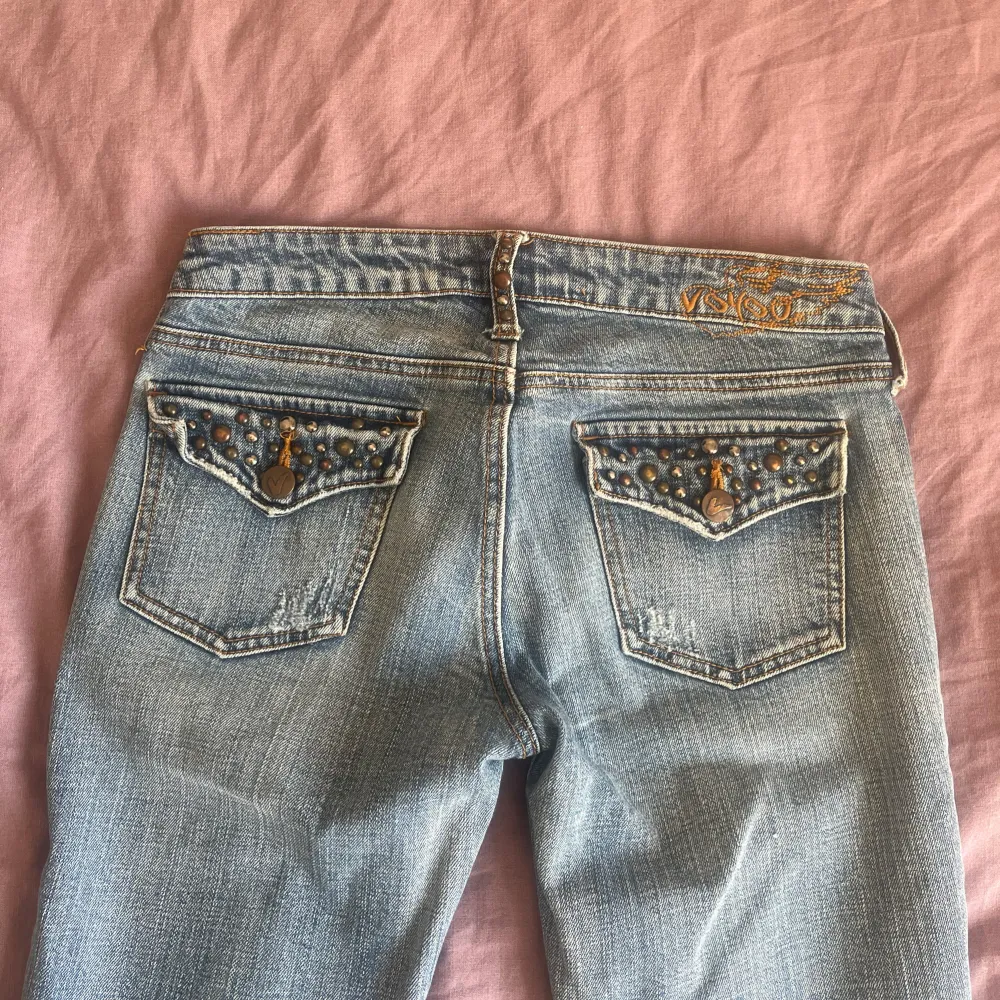 lågmidjade utsvängda y2k jeans. Detaljer både bak och fram! Bild 4 representerar färgen bäst! Tvärs över midja: ca 36 cm Innerbenslängd: ca 80 cm Benvidd längst ner: 22 cm Grenhöjd: 18 cm. Jeans & Byxor.