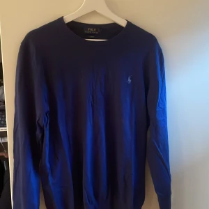 Tröja Ralph Lauren - Härligt blå stickad tröja från Ralph Lauren. Använd men i ett fint skick som gärna vill få en ny bärare.