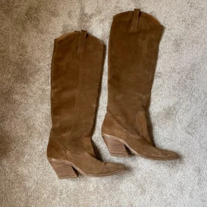 BRONX cowboyboots - Fina cowboyboots från BRONX. Använt ett par gånger, fint skick. Storlek 37. Ljusbrun mocka. 7cm klack, 50cm hög (från hälen till skaftet). Otroligt snygga! 