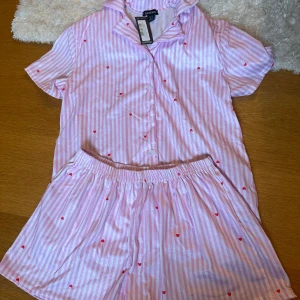 Pyjamas set Bohoo - Säljer ett gulligt pyjamas set från bohoo i storlek 36. Rosa vit randigt med hjärtan på. Aldrig använda. Hör av dig för fler bilder. Nypris 451kr