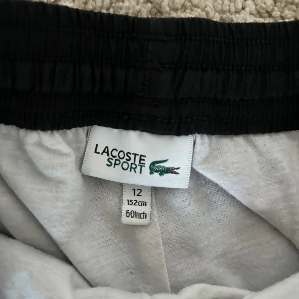 Lacoste sport byxor med zip vid smalbenen, väll använda i skick 8/10 i storlke 152 men är lite stor i storleken . Jeans & Byxor.