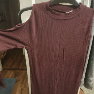 Stickad klänning - ”Öppen” vid axlarna Storlek L  Vinröd