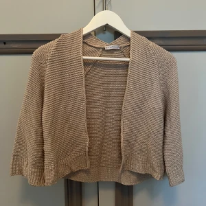 Trekvartsärm kofta - Jättesnygg beige-glittrig kofta med trekvartsärm. Gör en outfit mycket snyggare. Skulle säga att den är storlek XS men funkar också för S. 💜