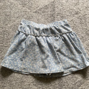 Kjol med inbyggda shorts - Säljer denna kjol från Zara som har blommigt mönster och inbyggda shorts. Storlek 152, 11-12år.