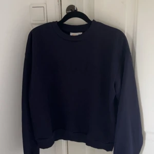 Mörkblå tröja från Gina Tricot - En mörkblå tröja från Gina Tricot i storlek 158/164. Tröjan har långa ärmar och en rund halsringning.