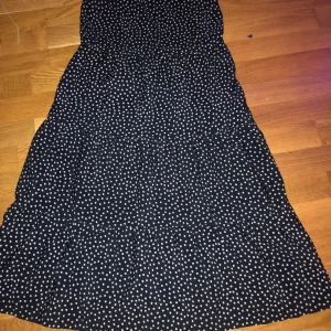 Svart klänning med vita blommor - Använd två gånger är förliten