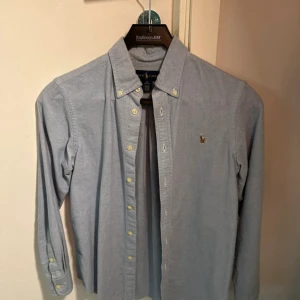 Ralph Lauren skjorta - Sjukt fräsch skjorta till sommaren. Säljer då den inte passar mig. Storlek 12 vilket är ungefär XS. Längd: 68 Bredd: 45. Skriv om ni har frågor! Pris kan diskuteras vid snabb affär😀