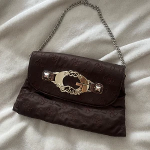 Liten guess väska  - Liten brun guess väska med broderier och kedja😍leopard mönster och ”orm skinn”  på insidan 💗fin vintage design med många fack  