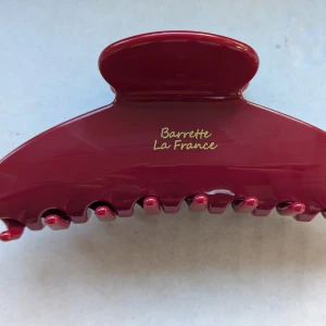 Vintage Röd hårklämma från Barrette La France - En elegant Vintage röd hårklämma från Barrette La France. Klämman har en glansig yta och är utrustad med en stark fjädermekanism för att hålla håret på plats. Perfekt för att skapa stiliga frisyrer.ny
