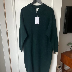 Grön stickad klänning  - Säljer en helt ny fin stickad grön klänning från Monki, fortfarande prislapp kvar! Vadlång. 