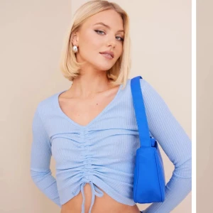 Ribbad långärmad - Ljusblå ribbad långärmad tröja i storleken XS. Köpt på Vero Moda och är i mycket bra skick. (Går att dra ihop snörena så tröjan blir kortare)