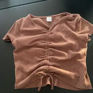 En super fin brun tröja med en liten ” skrynklig” rand  i mitten❤️ samt en rosett längst ner