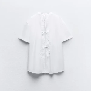 T shirt zara - Säljer den här så coola t shirten från zara med knytning där bak! Så najs oversized passform också. Säljer då jag inte hann lämna tillbaka alltså helt ny med prislappen kvar😌😌