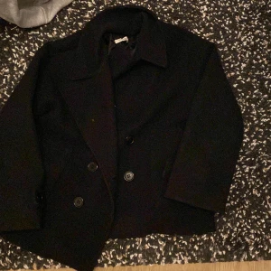Design by si kappa  - Svart Gina coat från design by si, den har ett litet hår på insidan av vänstra ärmen och ett större hål på hörna ärmen, bara Andvänd i 3 månader, säljer för att den är för kort i armarna på mig. Original pris, 700 ny pris, 330 