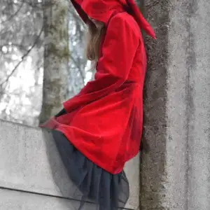 Velour coat with pointy hood. Hand colored, red with black strip. Closing in the front by a serie of buttons. In great confitions. I am gladly providing more pictures.