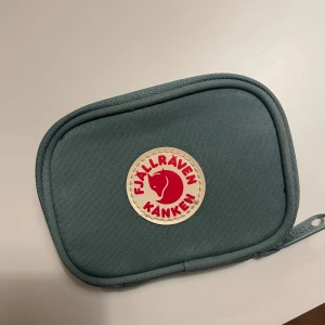 Korthållare  - Kånken plånbok/korthållare. Knappt använd. Plats för kort och ett myntfack. Mer blågrön i verkligheten än vad det ser ut som. Skriv för fler bilder. 