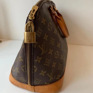Monogram Canvas ”Alma” - Fin Monogram Canvas Alma väska vintage från Louis Vouitton ingår äkthetsbevis och dustbag. Finns tyvärr ingen nyckel till låset. Vill ni ha fler bilder så får ni gärna kontakta mig.  Serienummer VI 1902 