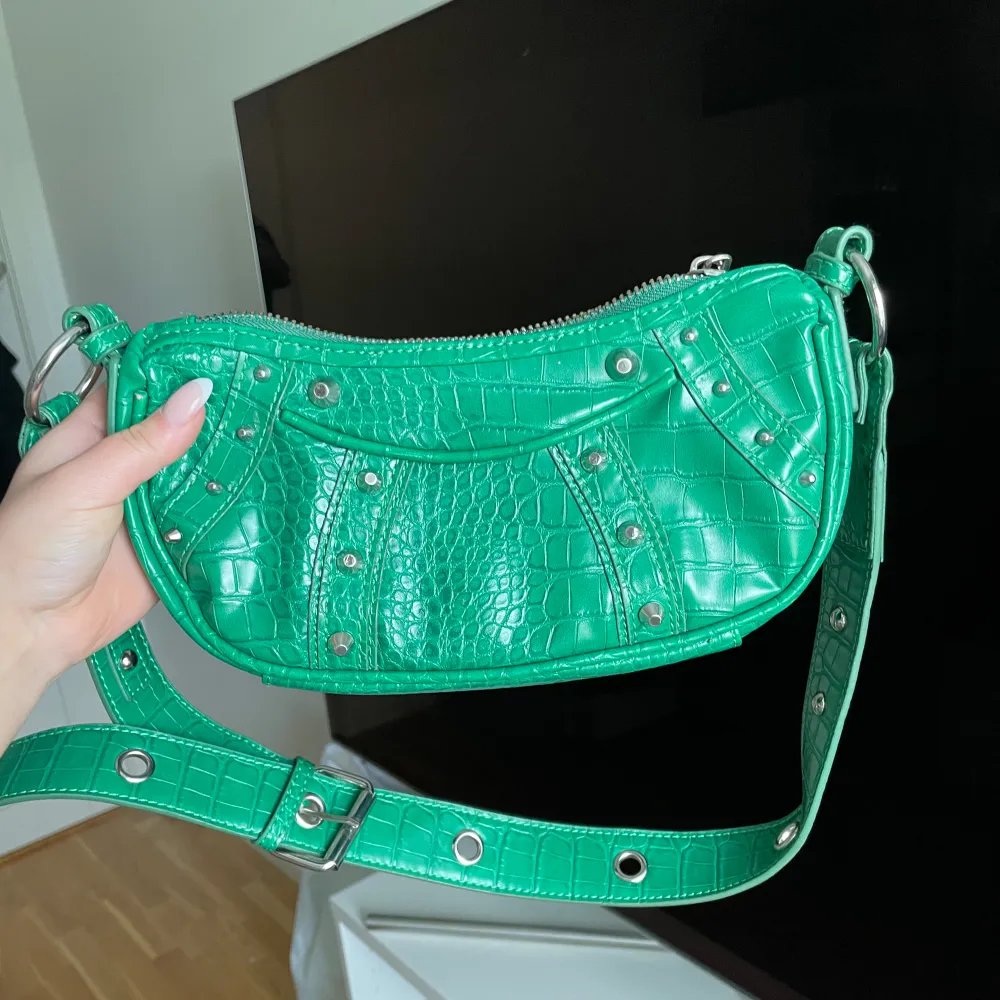 Skit snygg grön väska från asos, använt en del.  Skit snygga silver detaljer och du kan reglera bandet. Väskor.