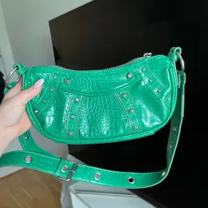Skit snygg grön väska från asos, använt en del.  Skit snygga silver detaljer och du kan reglera bandet