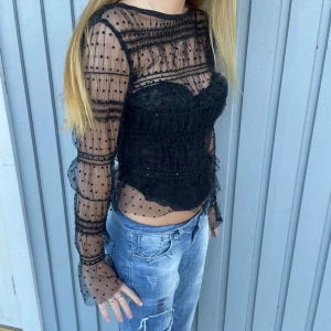 Mesh topp - Säljer denna mesh topp från Lindex med volanger och små prickar. Säljer korsetten under separat, alltså hör de inte ihop.💕 endast använd 1 gång