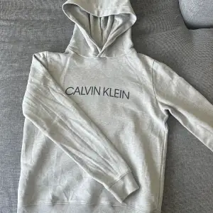 Säljer denna stilrena Calvin Klein Jeans hoodien i storlek för barn i 11-12 år åldern. Skick stark 9/10. Självklart tvättad och strykt. Köpt i Kids Brand Store. Vid minsta lilla funderingar är det bara att höra av sig. Priset kan diskuteras.