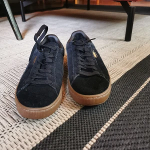 Puma sneakers  - Storlek 38. Svart mocka med guld detalj. Oanvända. Originallartongen skickad med.