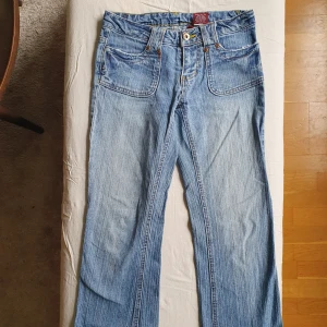 Lågmidjade flared jeans st 26 - Supersnygga lågmidjade jeans i storlek 3 (ungefär 26 skulle jag säga). Klippta nedtill. Perfekta i längden för mig som är 157cm lång.