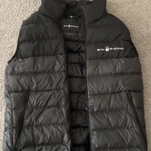 Sail racing väst - SAil racing väst svart och grå. Dragkedjan är nästintill förstörd och är väldigt svårt att få upp den 