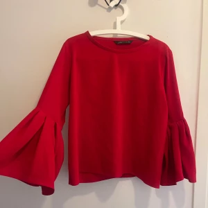 Zara röd blus med Trumpetärm - Zara röd blus med Trumpetärm Storlek: L  Liten reva på insidan av tyget, syns lite på utsidan, se bilder. Därav det låga priset.  Skrynklig pga flytt, men allt är rent och tvättat ✨ 