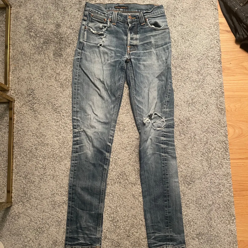 Säljer dessa feta Nudie jeans med slitningar tyvärr är det hål i fickorna men det går enkelt att sy Storlek 30/34 299kr. Jeans & Byxor.