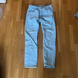 Ett par ljusblå jeans från Weekday i storlek 28/30. Modellen är Pine Regular Tapered Jeans.