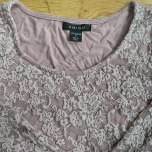 Rosa spetsblus från Amisu - En elegant rosa spetsblus från Amisu med ett blommigt mönster. Blusen har trekvartsärmar och en rund halsringning. Perfekt för både vardag och fest.