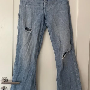 Jeans stl.34 - Snygga jeans, långa ben och loose fit. Hål som snygga detaljer på olika ställen. Sparsamt använda.