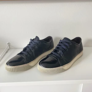Lanvin - Säljer nu ett par lanvin med glansig cap toe. Skorna är i bra skick med endast en skada i ena hälen. Hör av er för bild! Utöver detta är de en riktigt fräsch sko som är riktigt snygg! Hör av er vid frågor eller funderingar! 
