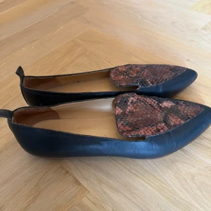 Loafers med ormskinnsmönster från ATP Atelier - Spetsiga loafers i ormskinnsmönster som passar lika bra till långa byxor som till bara ben. Bra skick, knappt använda