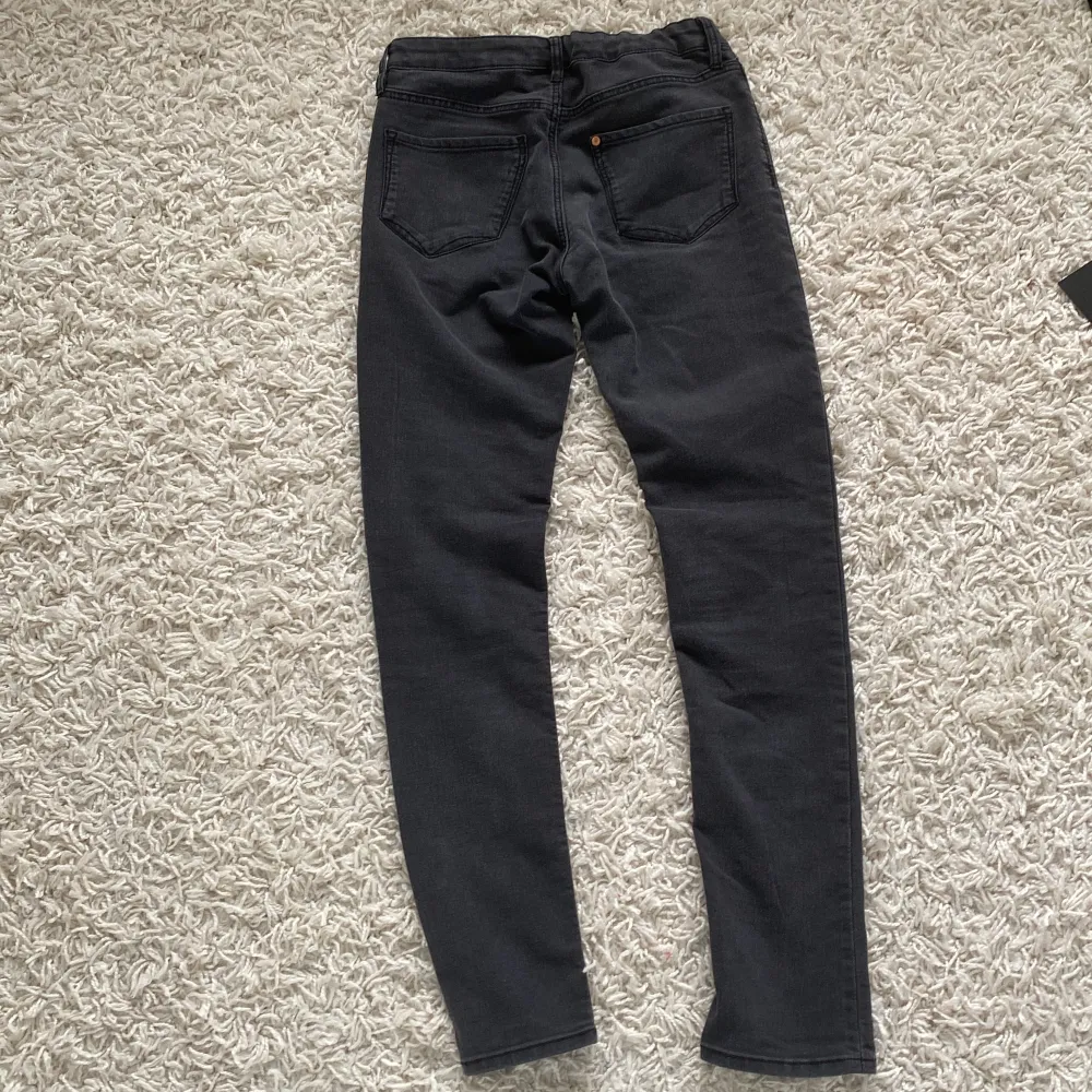Ett par svarta skinny fit jeans i storlek 152. Byxorna har en knapp och dragkedja framtill samt fickor både fram och bak. Tillverkade i Bangladesh.. Farkut & Housut.