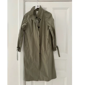 Trenchcoat Elvine  - Vintage inspirerad trenchcoat från Elvine  Färg: Grön/beige  Skick: Oanvänd 