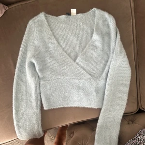 Babyblå stickad topp, med urringning.  - Jättefin stickad babyblå topp som passar fint både till vardags och till fest