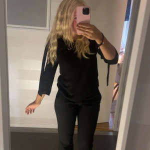 Svart knytblus  - En blus med fina detaljer i ryggen. Är från Gina men går inte att få tag på längre.