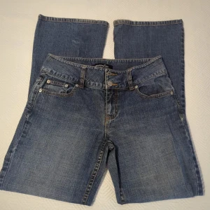 Vintage low rise jeans från London jean - Mellanblå stentvättade lågmidjade jeans. Flare i benen. Storlek S/37