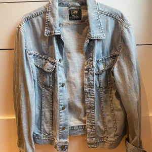 Lee-Jeansjacka - Ljusblå jeansjacka från Lee. Passar XS-L då den är aningen liten i storleken om man vill ha den oversized.  Inköpt för ca 5år sedan.