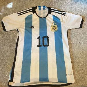 Argentina Messi tröja storlek S - Säljer en fin Argentina tröja med Messi på ryggen. Använd 2 gånger och ser som ny ut. De är Argentinas tröja när de van vm 2022. Storlek S