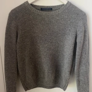 BRANDY MELVILLE - grå stickad tjock tröja som aldrig har kommit till andvändning från Brandy Melville. Står ingen storlek men är ungefär en XS/S. Nypris 355kr