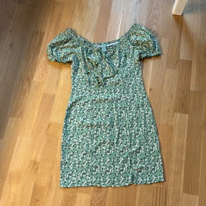Blommig miniklänning  - Fin blommig miniklänning med knytning vid bysten 💚