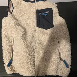 Patagonia väst - Patagonia väst i lite fluffigare material. Strl L men funkar också till M. Perfekt till sommarn,vår och höst Skick 9/10 använd cirka 6 gånger. Säljer pga vuxit ur