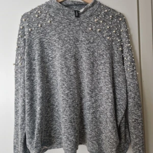 Tröja med pärlor  - Storlek: L. Jag är en M och är inte överdrivet stor.  Material: 58% Polyester, 39% Viscos, 3% Elastan.  Fin tröja från HM med pärlor på axlarna.  Använd, men i fint skick !  