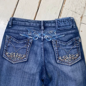 Y2k Jeans  - Blå y2k jeans men jättesnygga detaljer både bak och fram :) säljer då de är lite för långa för mig💙 Innerbenslängd: 82cm Midja tvärs över: 36cm. Skriv för fler bilder😚